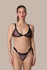 Woman wearing a black fishnet bikini against a gray background