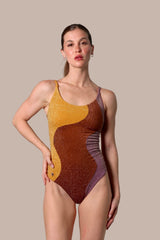 Woman wearing a brown and yellow patterned swimsuit against a plain background